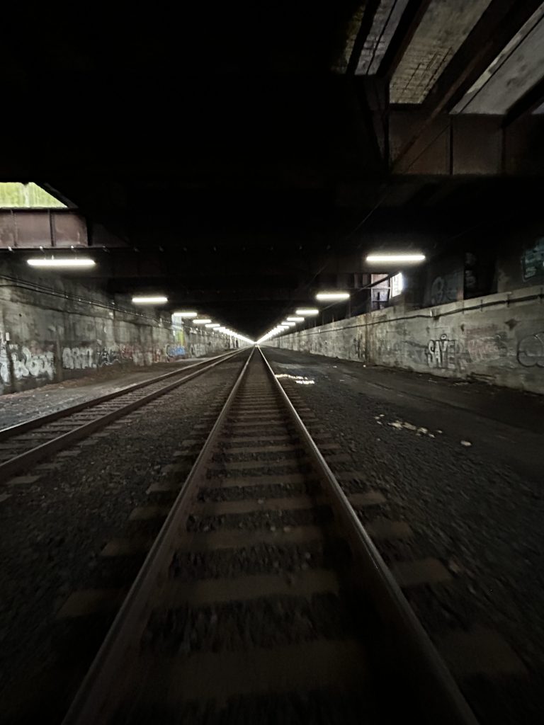 Active amtrak train tracks with a graffiti filled tunnel
